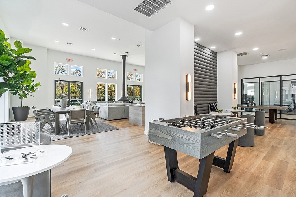 A foosball table is in the middle of a room with a couch and chairs.