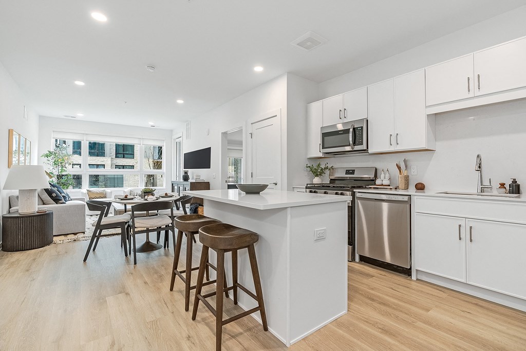 A modern kitchen with white cabinets and a wooden island.