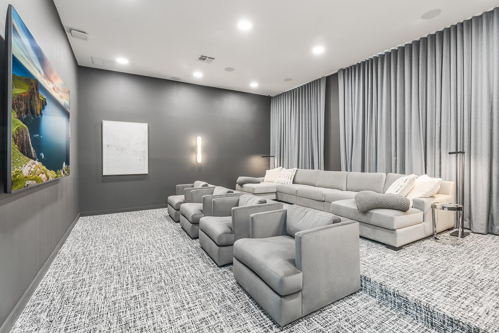 a large living room with gray walls and gray couches and chairs