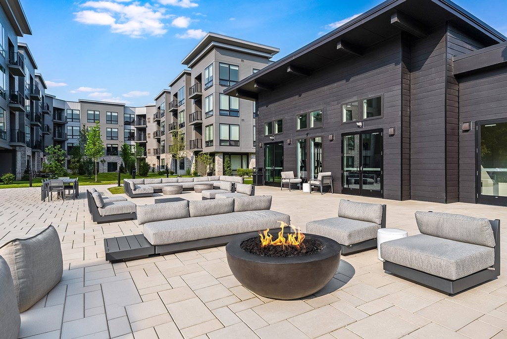 A modern outdoor seating area with a fire pit in the center.