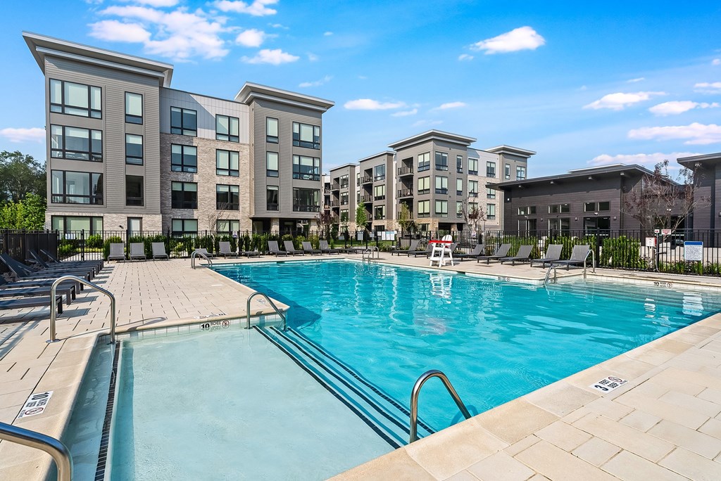 A swimming pool in front of apartment buildings.