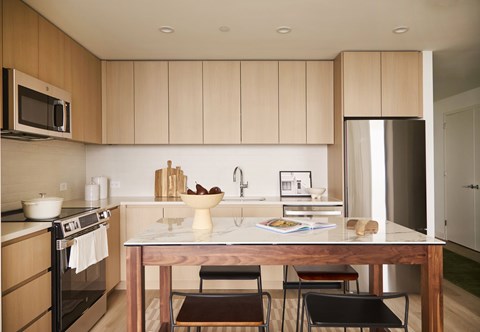 A kitchen with a table and chairs in the foreground.