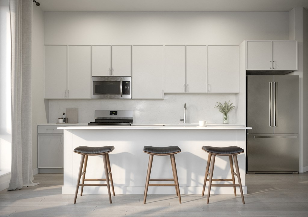 a kitchen with white cabinets and a counter with three stools