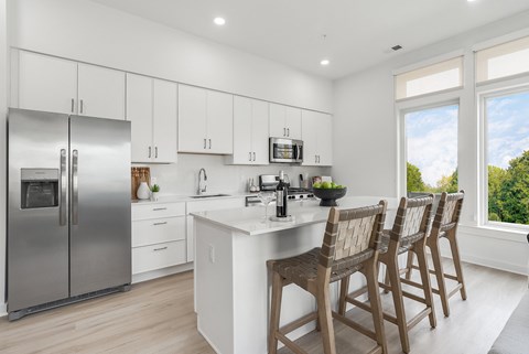 A modern kitchen with white cabinets and a large island.