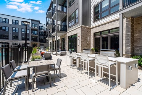 A patio with a table and chairs is surrounded by buildings.
