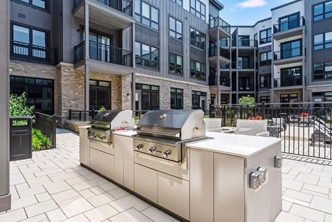 A modern outdoor kitchen with a grill and sink.