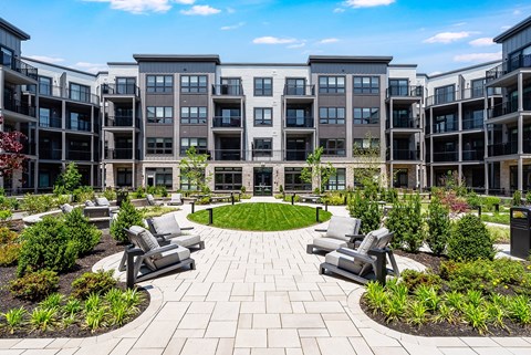 A courtyard with a circular walkway and benches surrounded by apartment buildings.