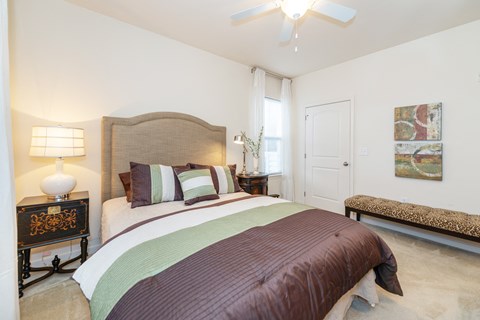 A bedroom with a large bed and a bench.
