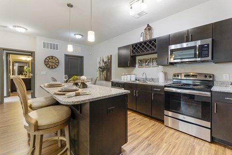 a kitchen with stainless steel appliances and a marble counter top