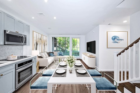 A modern kitchen with a dining table set for two.