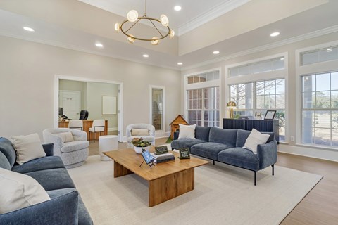 A living room with a blue couch and a wooden coffee table.
