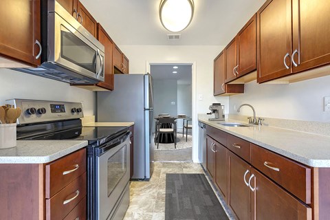 A kitchen with wooden cabinets and a stainless steel refrigerator.
