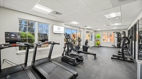 A gym with treadmills, elliptical machines, and other exercise equipment.