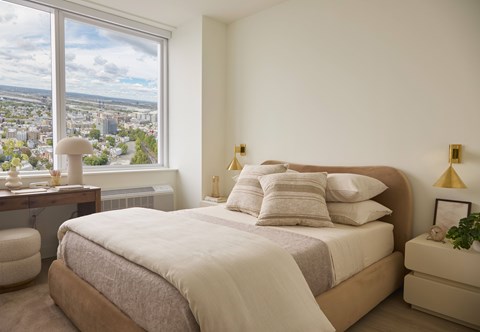 A bedroom with a large bed and a view of the city.