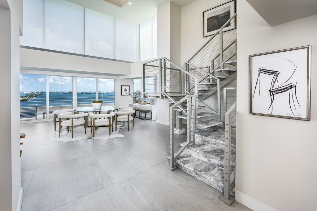 A modern interior with a staircase and a table with chairs.