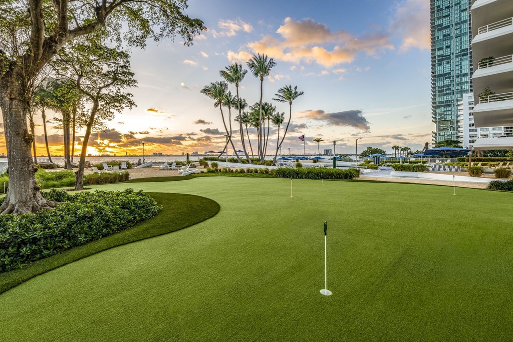 A golf course with a green and a flag on the green.