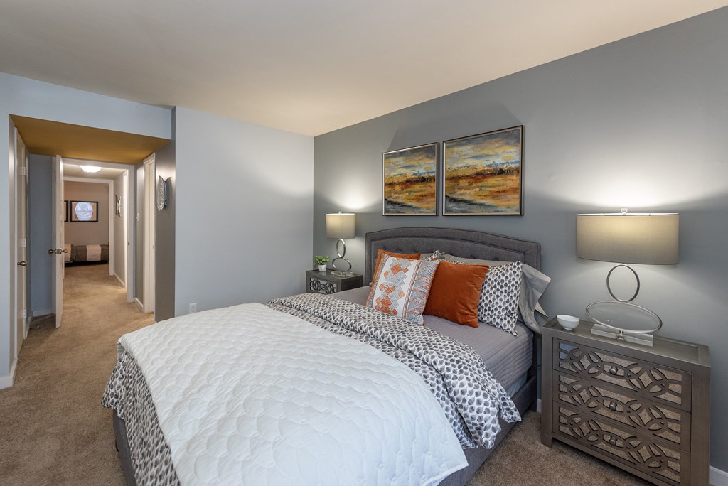 a bedroom with a large bed and a hallway to a bathroom