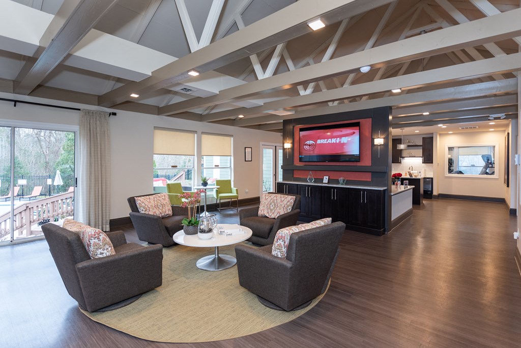 a living room with couches and chairs and a television