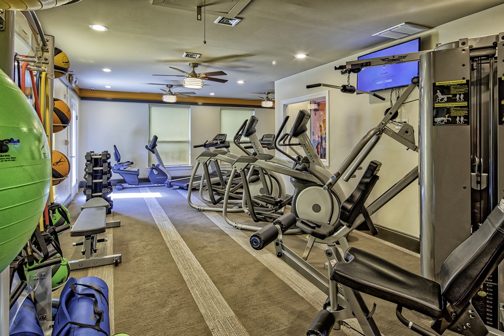a home gym with exercise equipment and a television