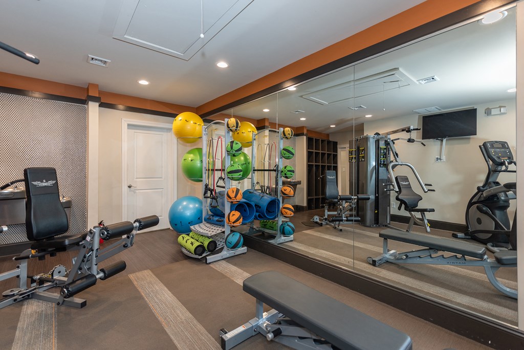 a home gym with exercise equipment and mirrors on the wall
