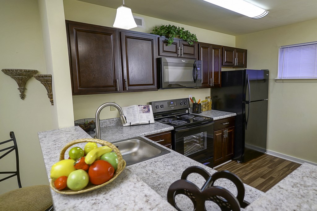 a kitchen with stainless steel appliances and a bowl of fruit