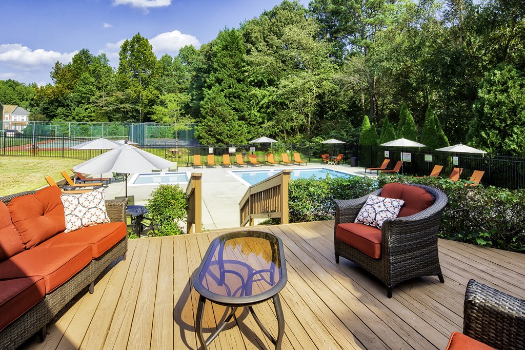 a backyard with a pool and patio furniture