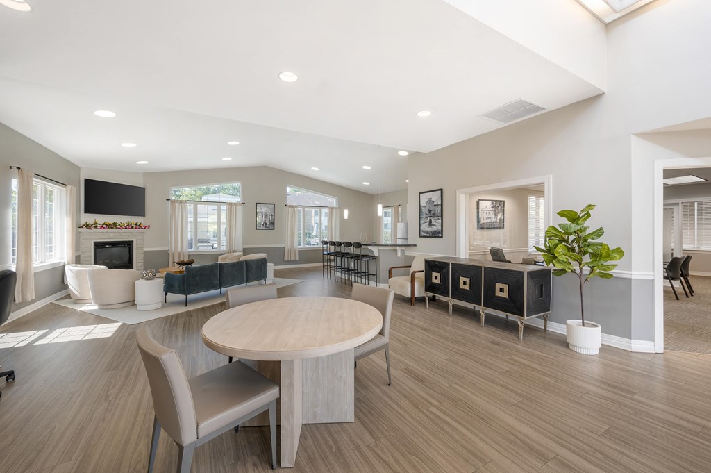A spacious living room with a large round table and chairs.