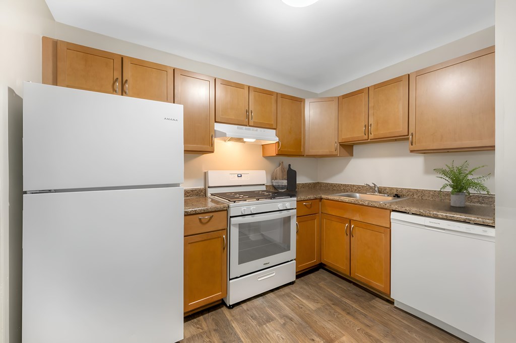 A kitchen with wooden cabinets and a white refrigerator.