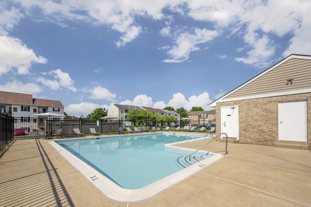 A large outdoor swimming pool with a sunny sky above.