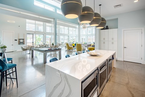 a large kitchen with a large island and a dining room with a table and chairs