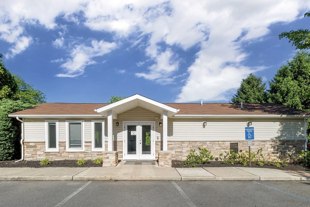 a small white house with a sidewalk in front of it