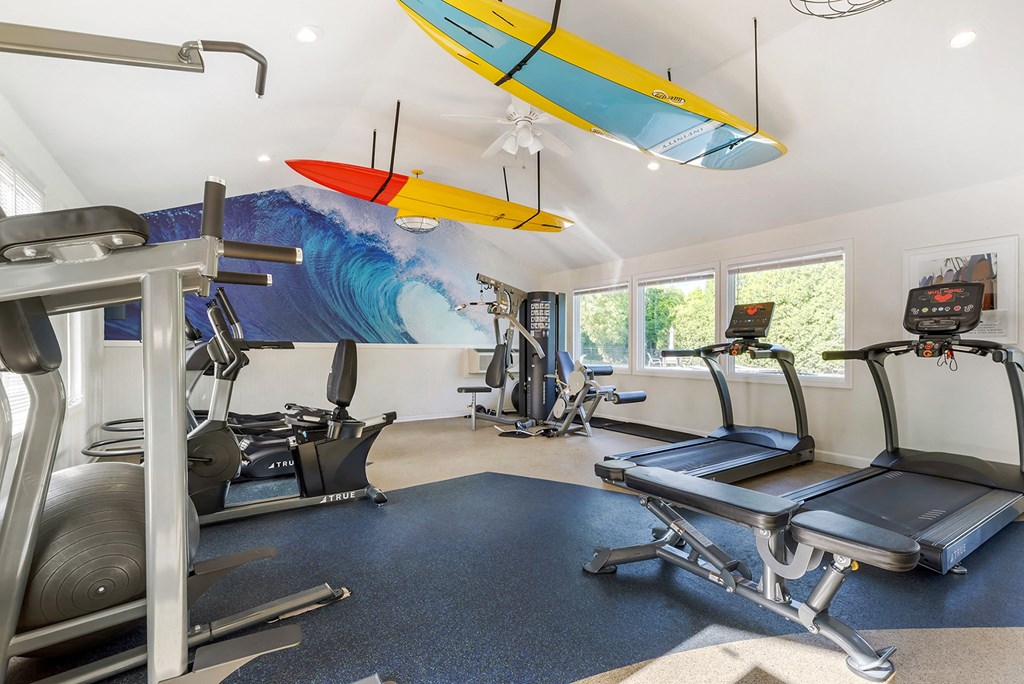a gym with cardio equipment and a surfboard on the ceiling at Quail Ridge, Plainsboro Township