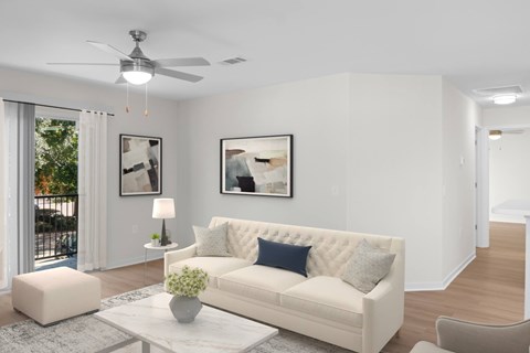A living room with a white couch and a ceiling fan.