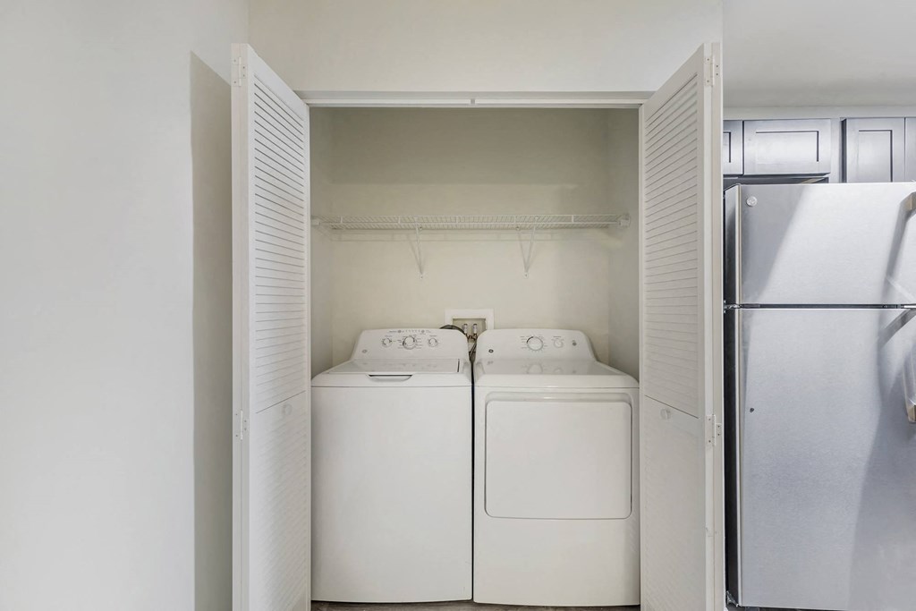 a laundry room with two washes and a refrigerator