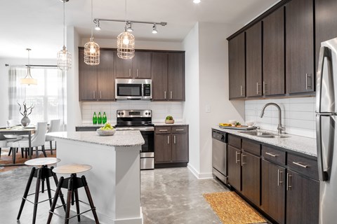 a kitchen with wooden cabinets and a white island with three stools