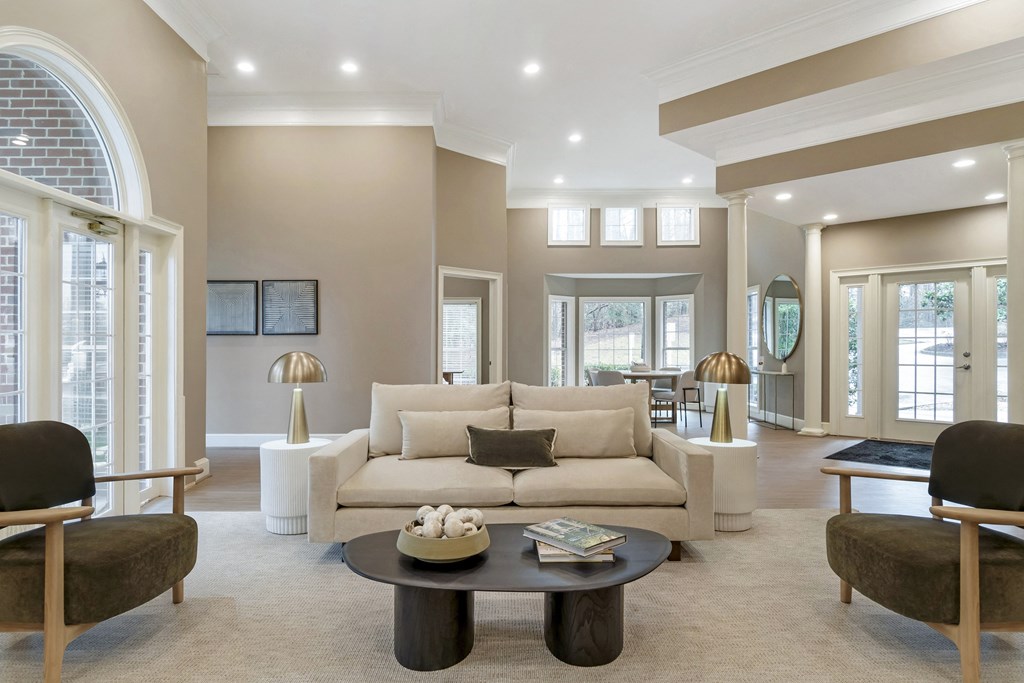 A living room with a white couch and a coffee table in the middle.
