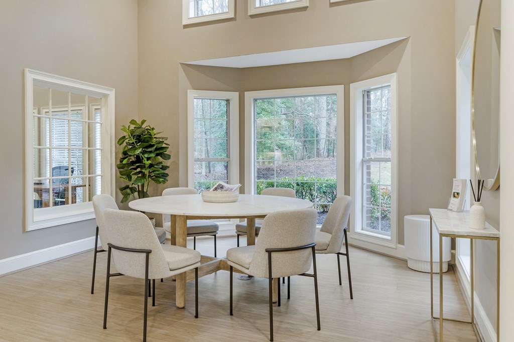 A dining room with a table and chairs.