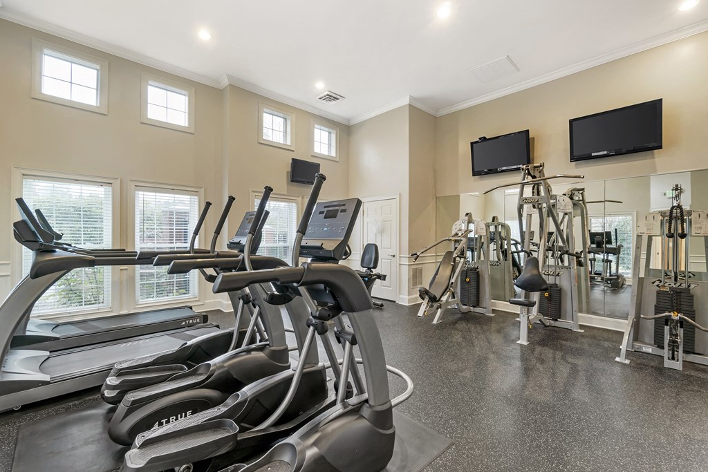 A gym with treadmills, exercise bikes, and other equipment.