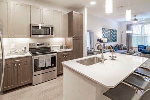 an open kitchen and living room with a large white counter top