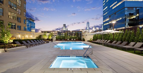 A large swimming pool surrounded by lounge chairs and umbrellas. at 65 Bay Street Apartments, Jersey City, NJ 07302