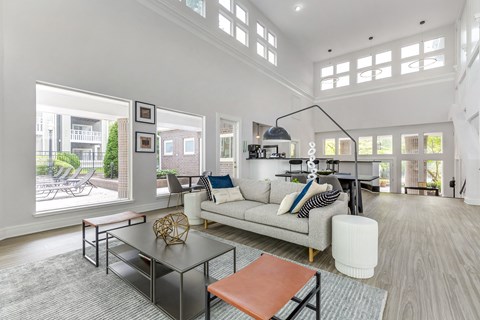A modern living room with a white sofa and a glass table.