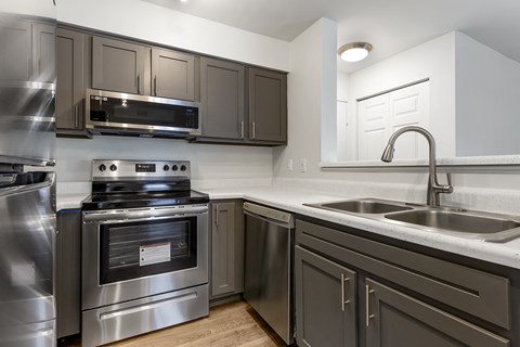 A modern kitchen with a stainless steel oven and sink.