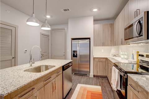 a kitchen with marble counter tops and a stainless steel refrigerator