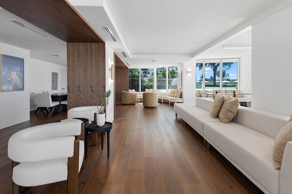 A modern living room with a white couch and a wooden floor.