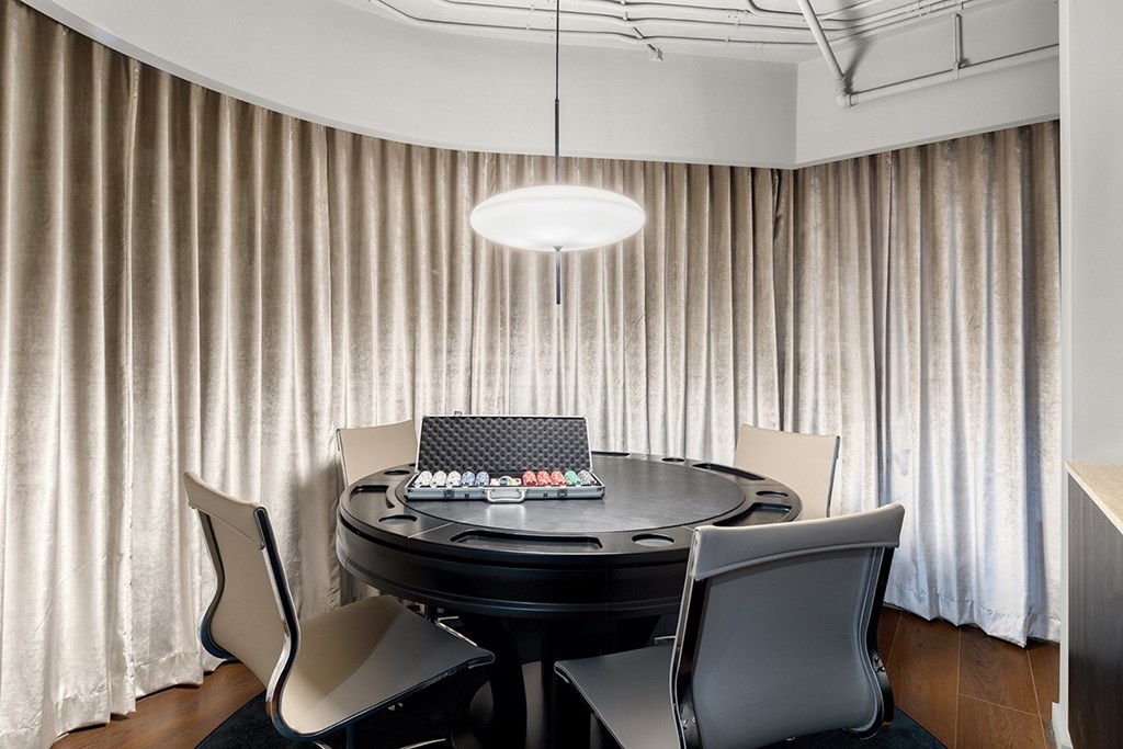 A round table with a black tabletop and four chairs around it.