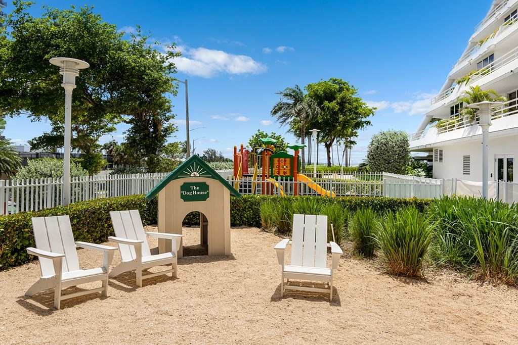 A sandy area with chairs and a playhouse.
