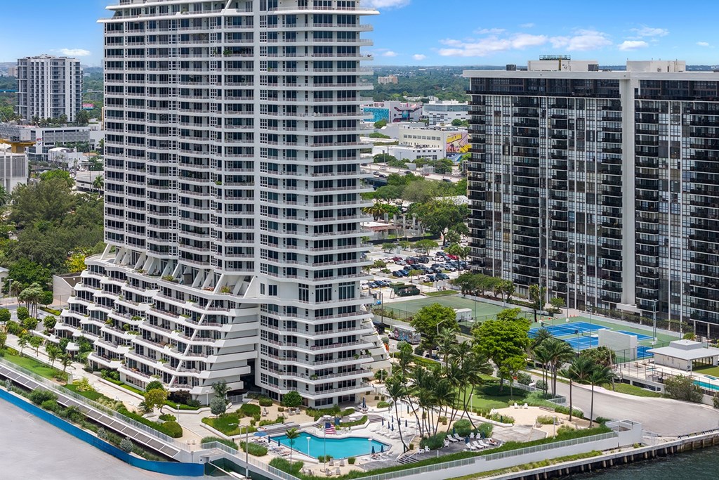 A large building with a pool in front of it.