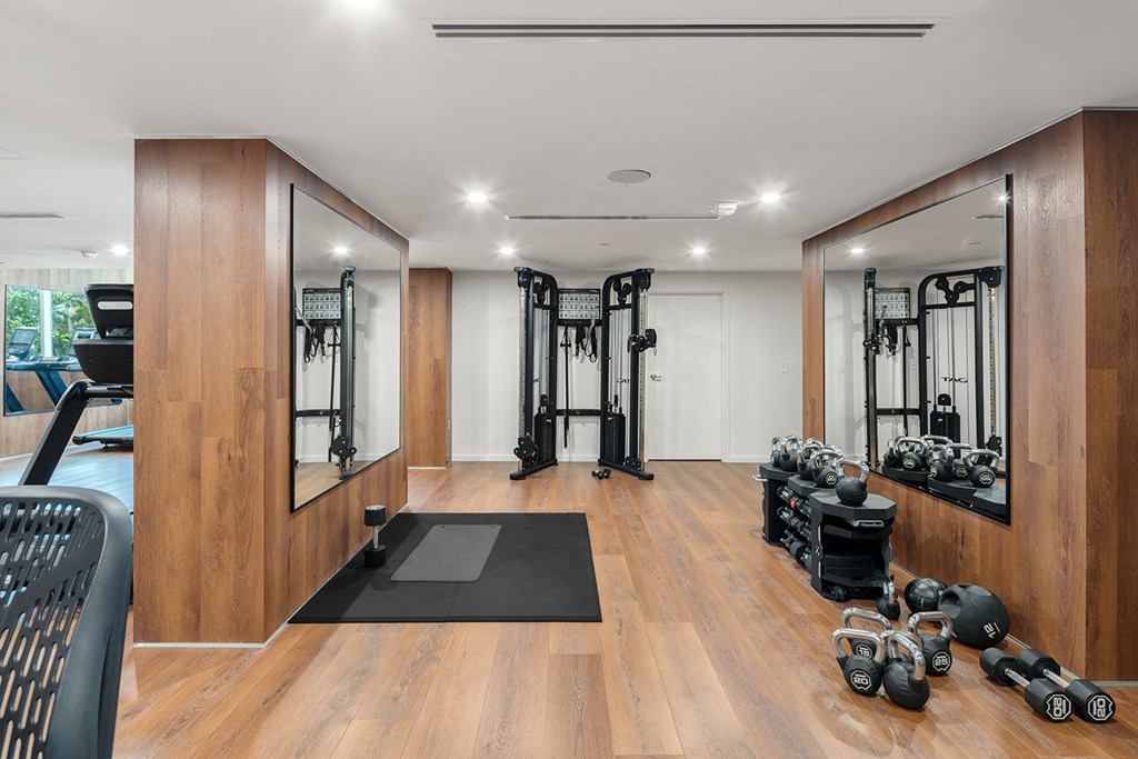 A gym with a variety of equipment including weights and exercise machines.