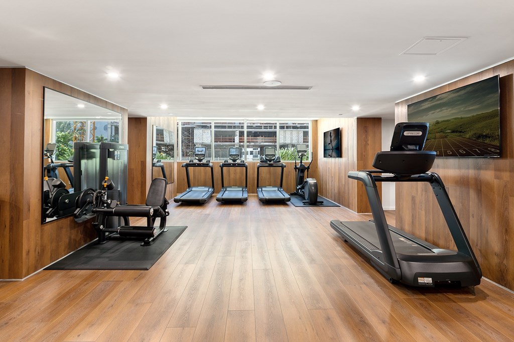 A gym with treadmills, exercise bikes, and other equipment.