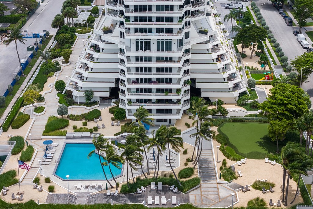 A large white building with a pool in front.